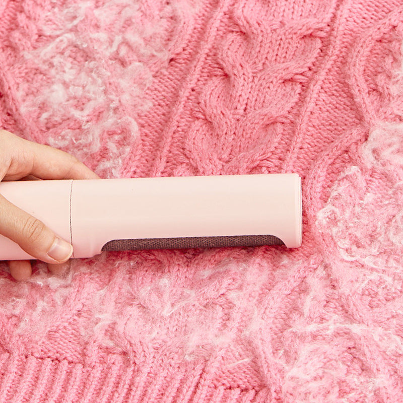 Blush Pink Coathaus Reusable Lint Brush lifting white lint from a pink cable-knit sweater