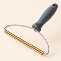 Coathaus Sofa & Carpet Fur Rake on a cream background showing the grey handle, steel frame and copper raking coils