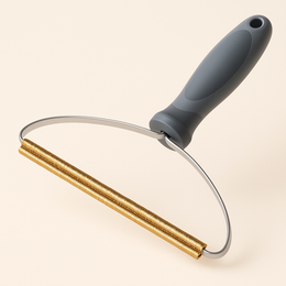 Coathaus Sofa & Carpet Fur Rake on a cream background showing the grey handle, steel frame and copper raking coils
